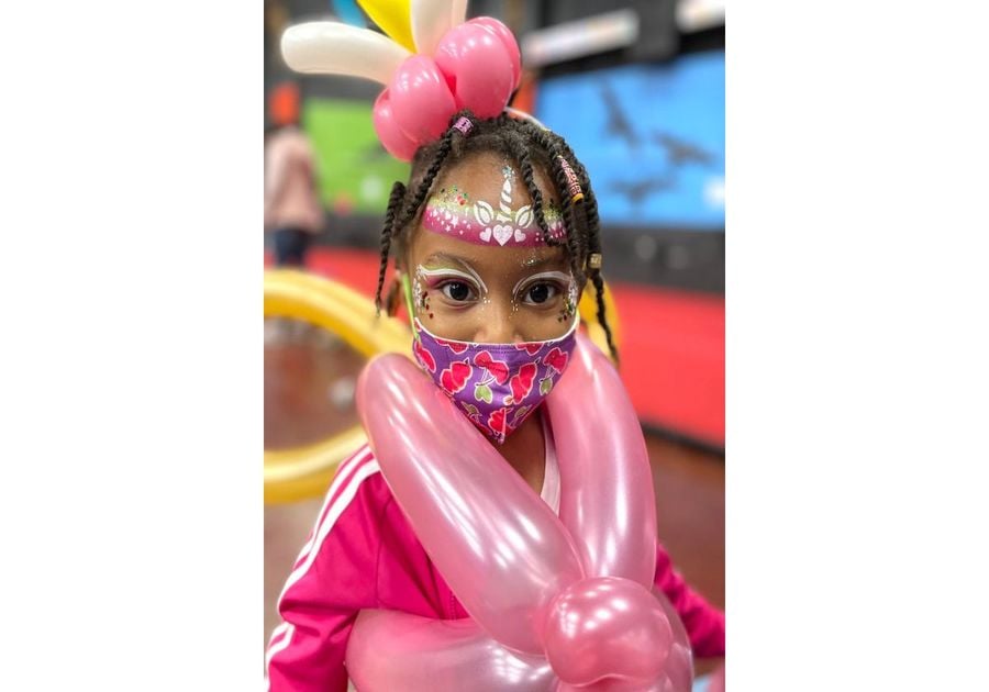 girl with facepaint and balloons