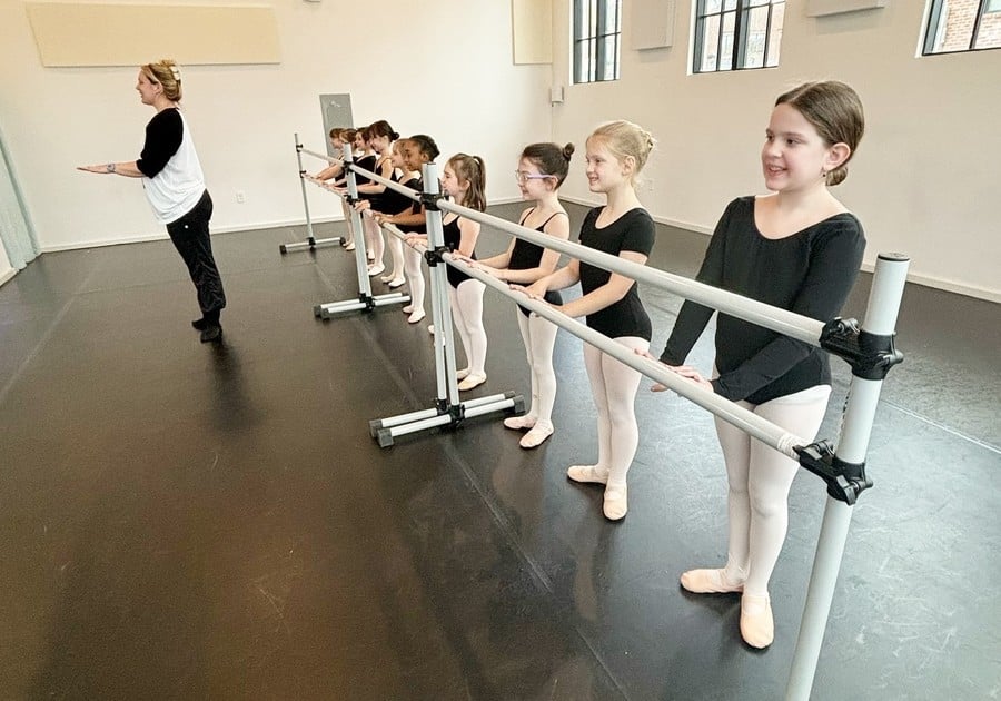 photo of young female dancers at ballet bar