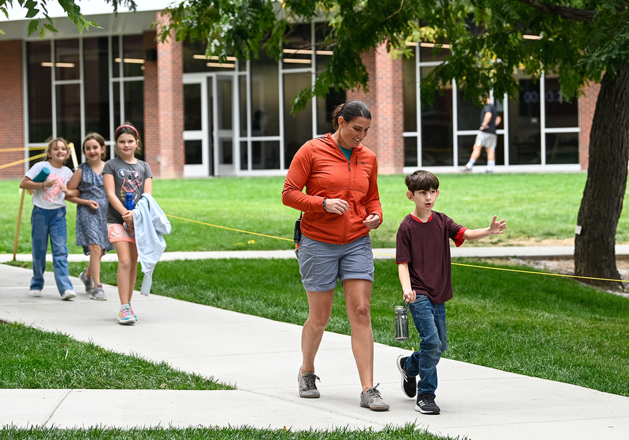 children and teacher walking together outside at Denver Academy Summer Camp